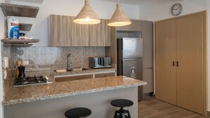 Eine moderne Küche mit Granit Arbeitsplatten, Edelstahlgeräten und Pendelleuchten.