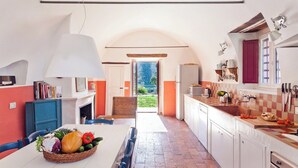 A kitchen with a central island, white cabinets, a checkered backsplash, and a view to the outside. - Casa Romito - Four Bedroom Villa, Sleeps 8 (Cefalù)