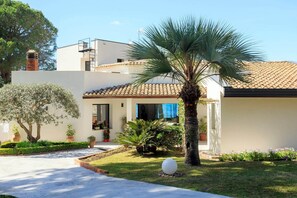 A modern house with a tiled roof, a small garden with a palm tree, and a white spherical sculpture. - Celeste - Four Bedroom Villa, Sleeps 8 (Brucoli)