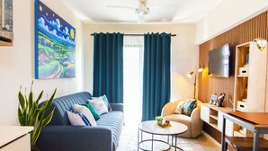 Uma sala de estar moderna com sofá, mesa de centro e aparador para TV.