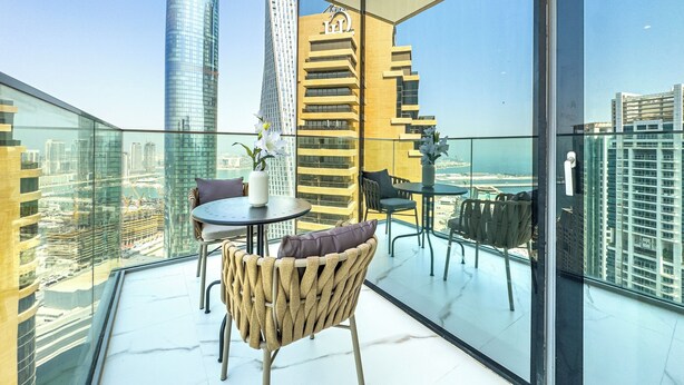 Ein moderner Balkon mit Glasboden, der einen Blick auf die Stadt und das Meer bietet.