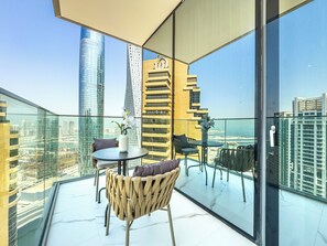 A modern balcony with a glass floor, offering a view of a cityscape and the sea. - Elegant 3BR Retreat | Panoramic Palm and Sea Views (Dubai)