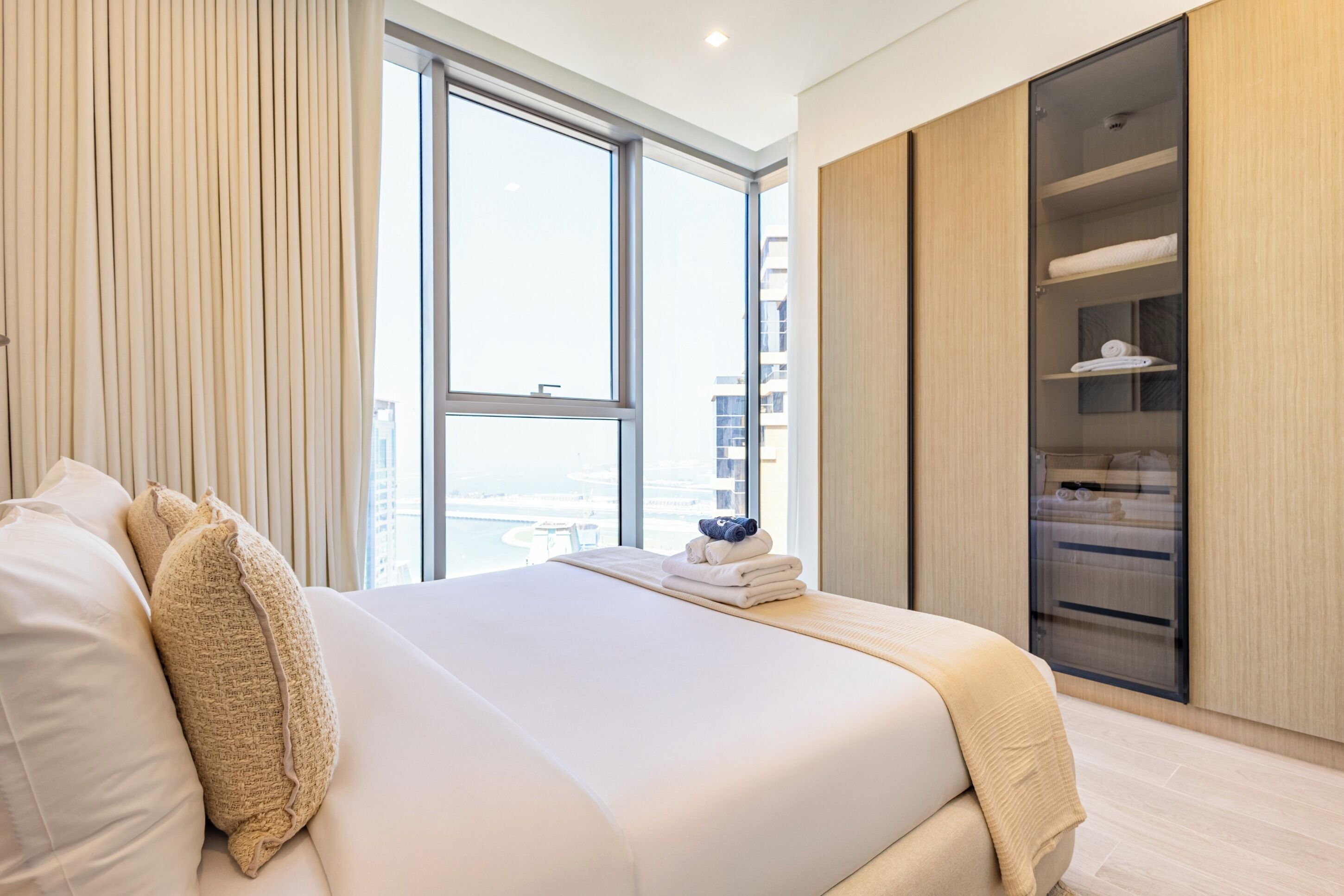 Une chambre d’hôtel moderne avec un grand lit, une armoire et une vue sur la ville.