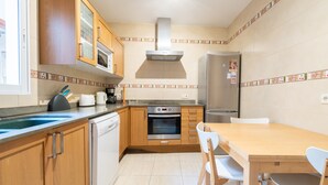A kitchen with wooden cabinets, a stainless steel oven, a microwave, and a refrigerator. - Holiday Home 'Casa Guillermo' with Mountain View, Wi-Fi and Air Conditioning (Pollensa)