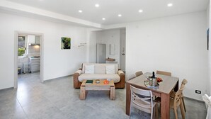 Un salon moderne comprenant un canapé, une table basse, une table à manger et des chaises.