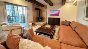 A cozy living room with a fireplace, a sofa, and a coffee table. - Stunning Mtn Condo - Prime Location, Walk to Ski Lifts & Main Street! (Breckenridge)