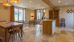 A spacious kitchen with wooden furniture, a dining area, and a view through the window.