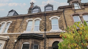 Un edificio histórico con fachada de piedra, varias ventanas y un letrero que dice 