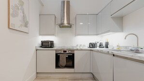Una cuina moderna amb microones, forn i campana extractora d'acer inoxidable.