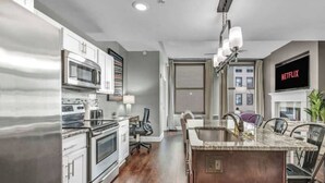 Una cocina moderna con electrodomésticos de acero inoxidable, una isla de madera y vistas a la ciudad.
