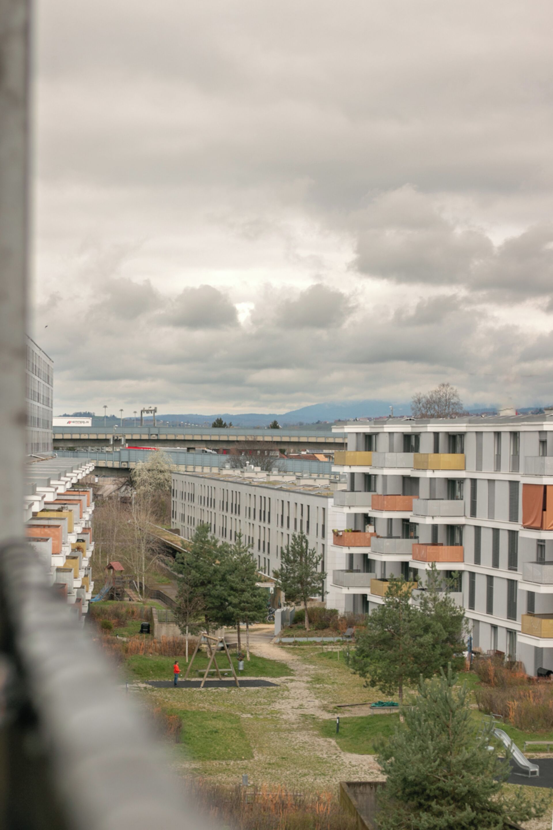 A residential building with multiple balconies and a central courtyard.