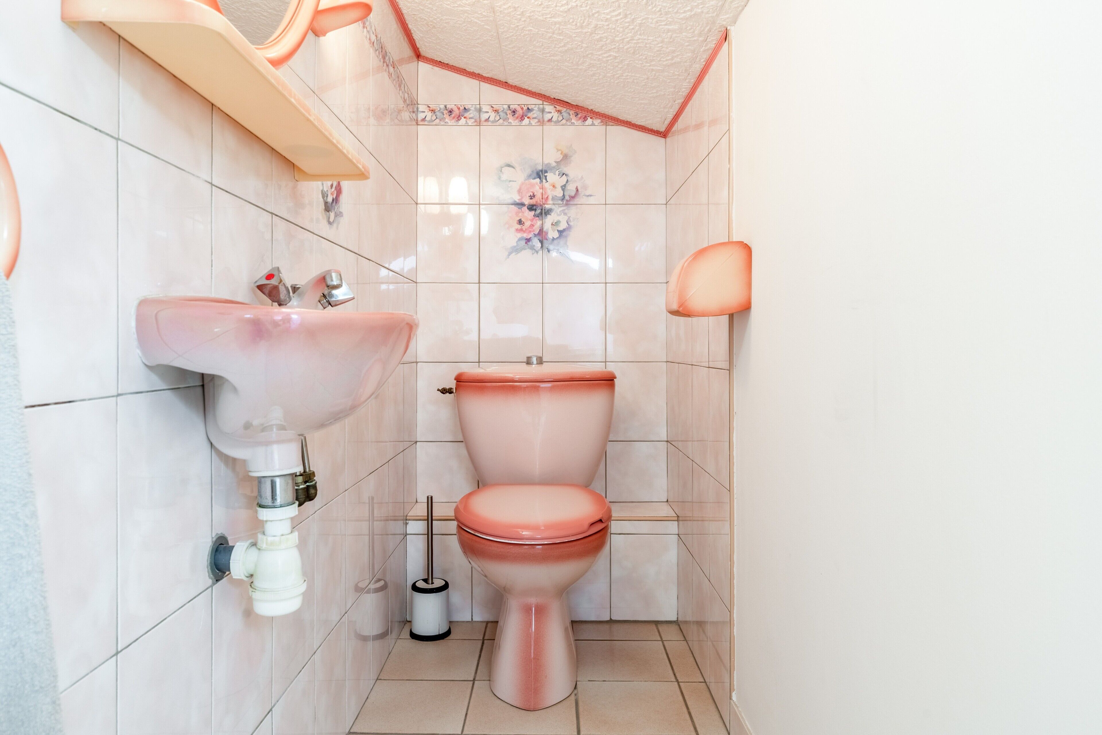 Un baño con inodoro, lavamanos y zona de ducha.