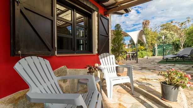 A patio with two white plastic chairs, a table, and a potted plant. - Rural House 'El Capricho de Rosmary' with Mountain Views and Private Garden (Villanueva)