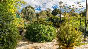 A garden with stone pathways, various plants, and a street lamp. - Rural House 'El Capricho de Rosmary' with Mountain Views and Private Garden (Villanueva)