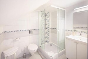 Regadera, secadora de cabello, toallas, papel de baño 