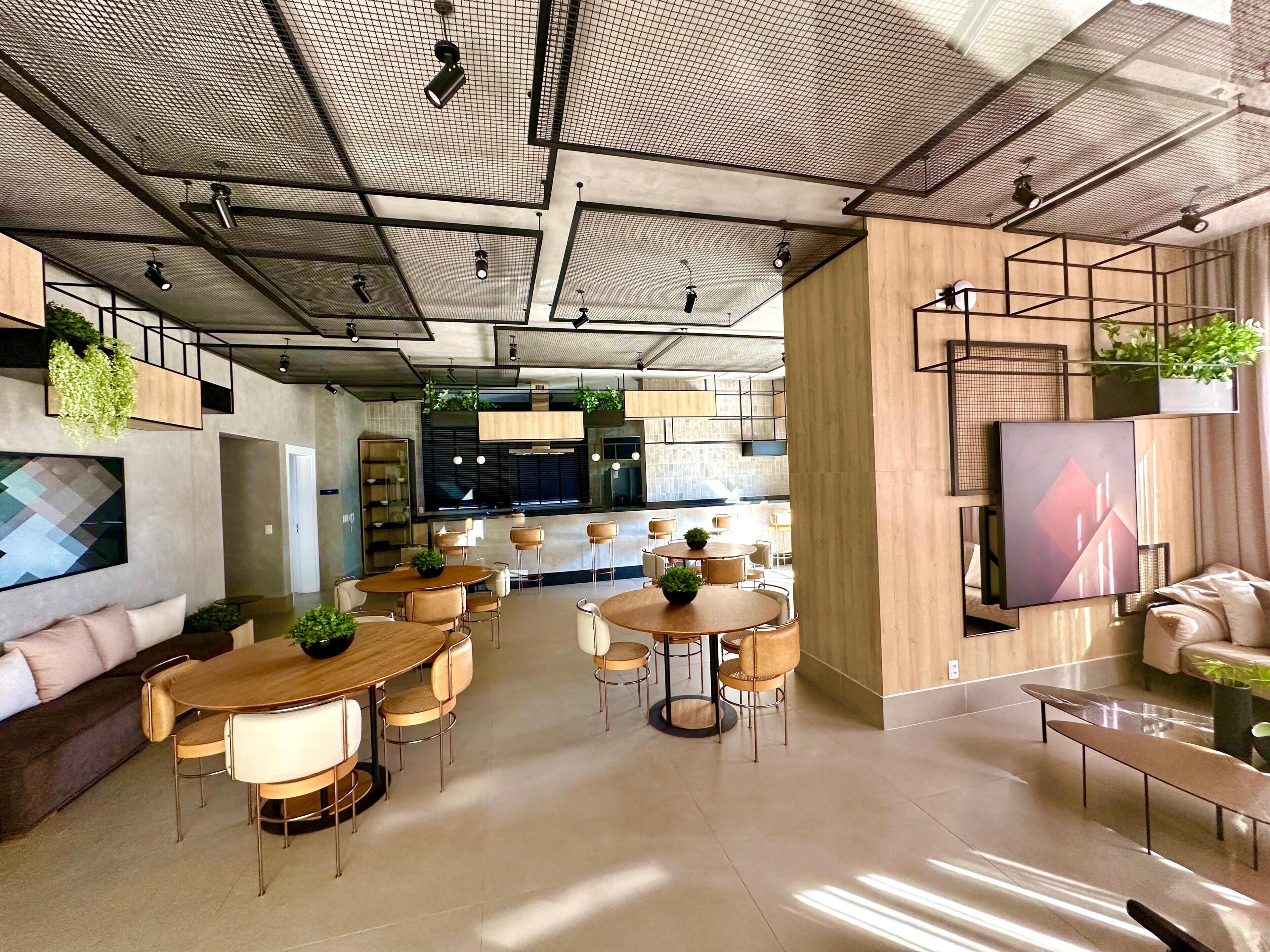 Un intérieur moderne comprenant un coin repas, des canapés et un écran de télévision.