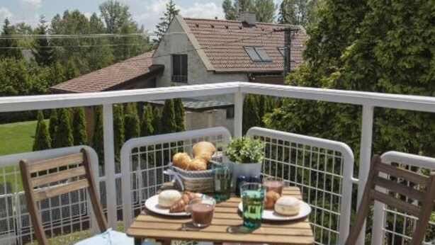A balcony with a table set for breakfast, including bread, pastries, and drinks. - TópART Apartman I: Apartment with terrace (Balatonfenyves)