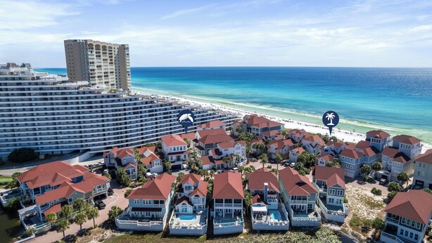 Une station balnéaire dotée de villas en bord de mer, d’un grand hôtel et d’une plage.
