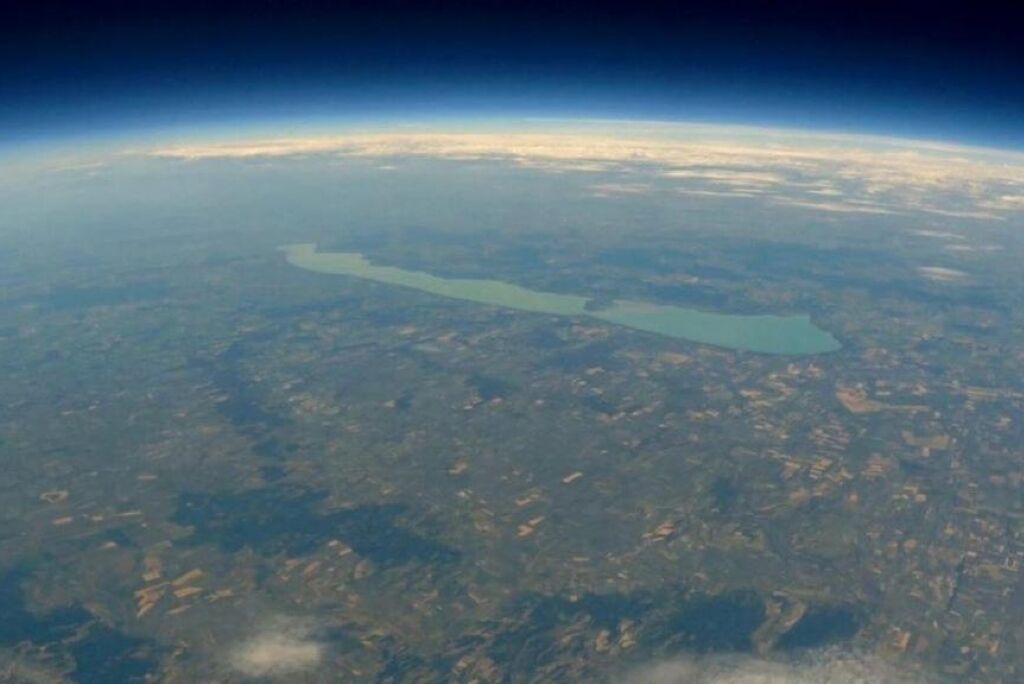 A large body of water surrounded by land with a clear view of the horizon.