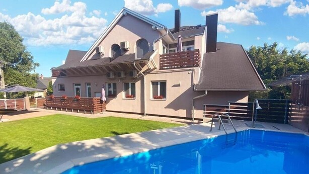 A two-story house with a swimming pool in the foreground. - TópART Apartman I: Apartment with terrace (Balatonfenyves)