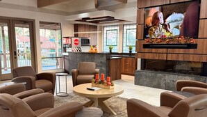 A modern living room with leather sofas, a coffee table, and a TV mounted on the wall. - STUNNING Views, SUBERB Location..NEW NEW NEW to The Racquet Club in Scottsdale! (Scottsdale)