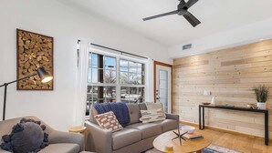 Un salon moderne avec un canapé, une table basse et un mur en bois.
