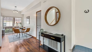 A modern living room with a dining area, a large mirror, and a bench. - NAU/DT | Elevated 2 bdrm | AC | Dog Friendly (Flagstaff)