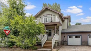 A two-story house with a front porch, a garage, and a driveway. - NAU/DT | Elevated 2 bdrm | AC | Dog Friendly (Flagstaff)