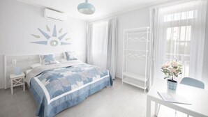 Ein helles, modernes Schlafzimmer mit einem großen Bett, einem Nachttisch, einem Hängekorbstuhl und einem Fenster mit Vorhängen.