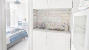 Ein modernes Badezimmer mit weißen Schränken, einer gefliesten Rückwand und einem sichtbaren Waschbereich.