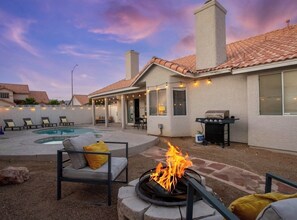 A backyard with a pool, a fire pit, outdoor seating, and a barbecue area. - Amazing 4BD Home w/Pool, Arcades, & Billiard! (Las Vegas)