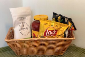 Ein Korbwägelchen mit einem Honigglas, einer Tüte Lay's Kartoffelchips und einer Flasche Charlotte's echtem Honig.