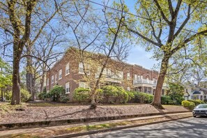 A two-story brick building with a front porch and a driveway.