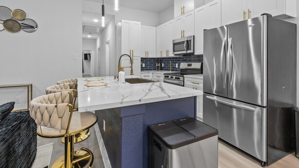 A modern kitchen with white cabinets, stainless steel appliances, and a marble island. - Spacious ,Luxury 3-bedroom apartment in Houston with Games ,Smart Tv,Wifi (Houston)