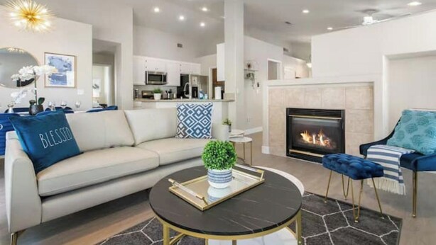 A modern living room with a sofa, a round coffee table, and a fireplace.
