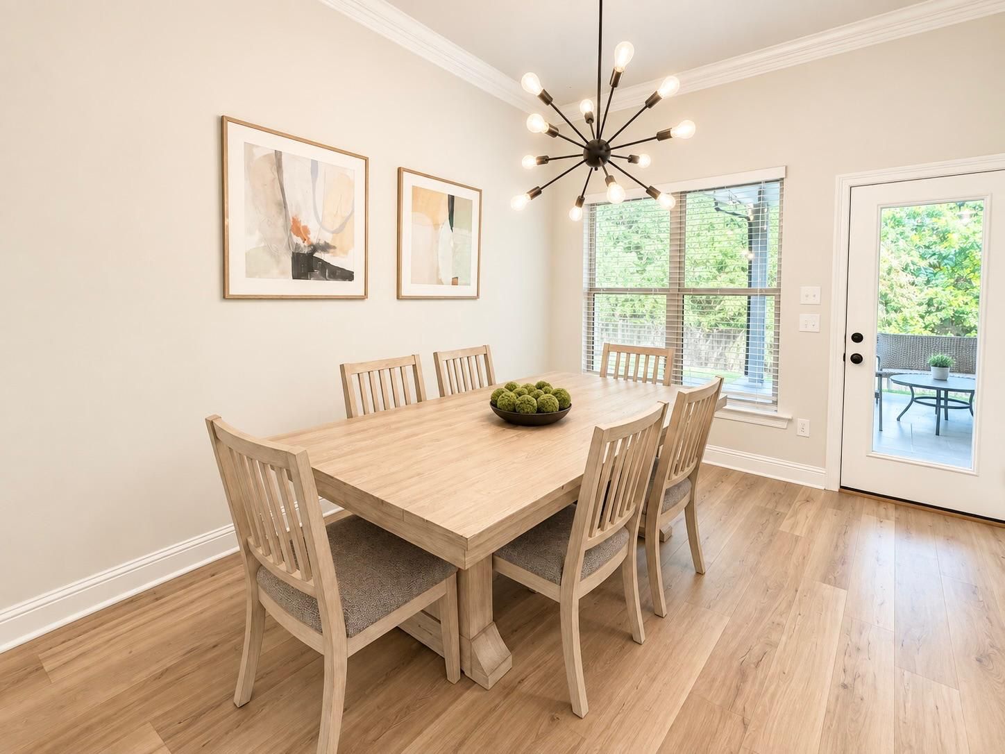 A dining room with a wooden table, six chairs, and a chandelier.