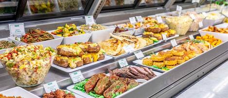 Un buffet proposant divers plats et une salade composée.
