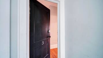 A dark wooden door with the number 3, white trim, and a keyhole.