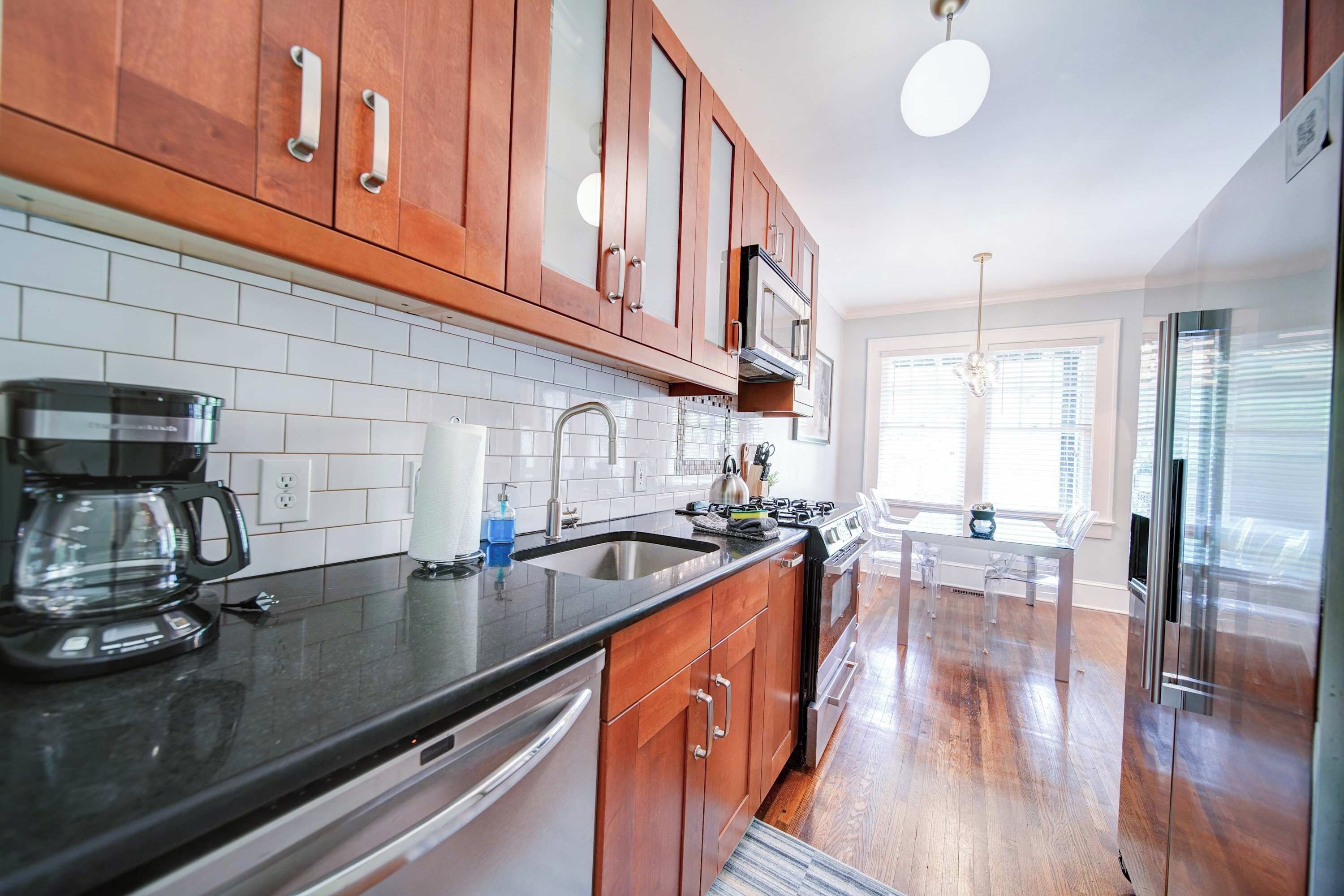 A modern kitchen with wooden cabinets, a stainless steel sink, and a built-in oven.