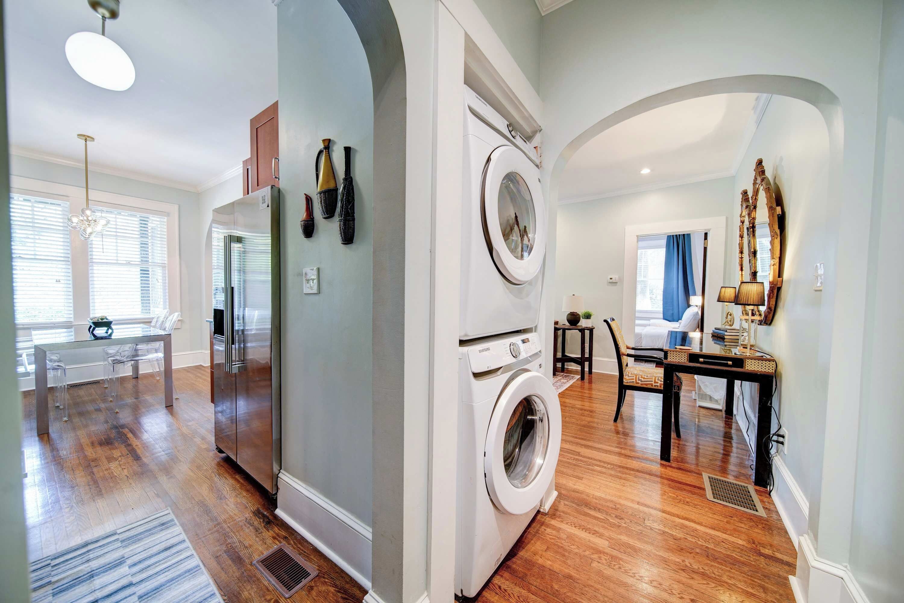 A modern kitchen with a refrigerator, microwave, and a washing machine.