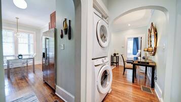A modern kitchen with a refrigerator, microwave, and a washing machine.