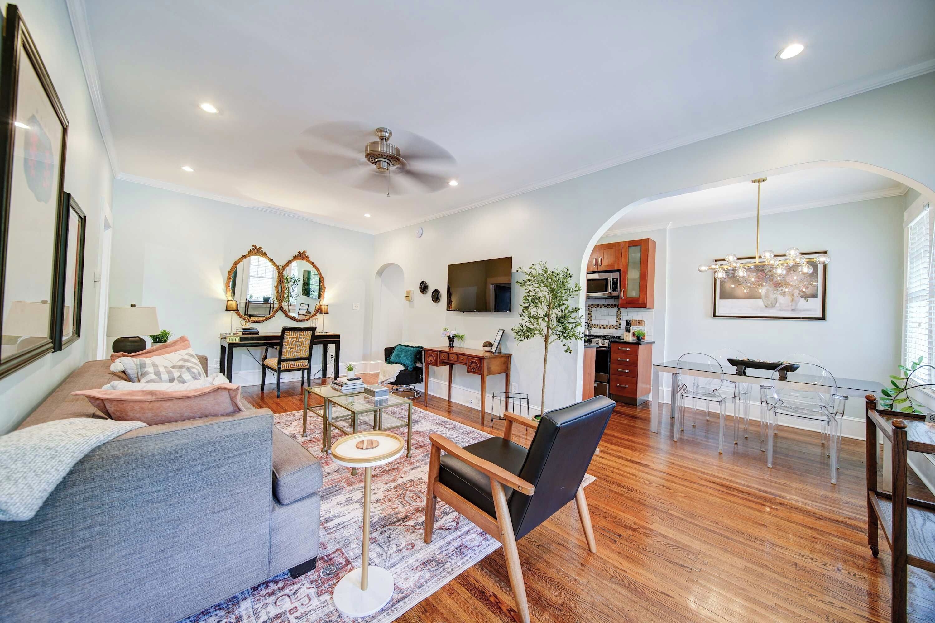 Un salon spacieux comprenant un canapé, une table basse et un coin repas avec des chaises.