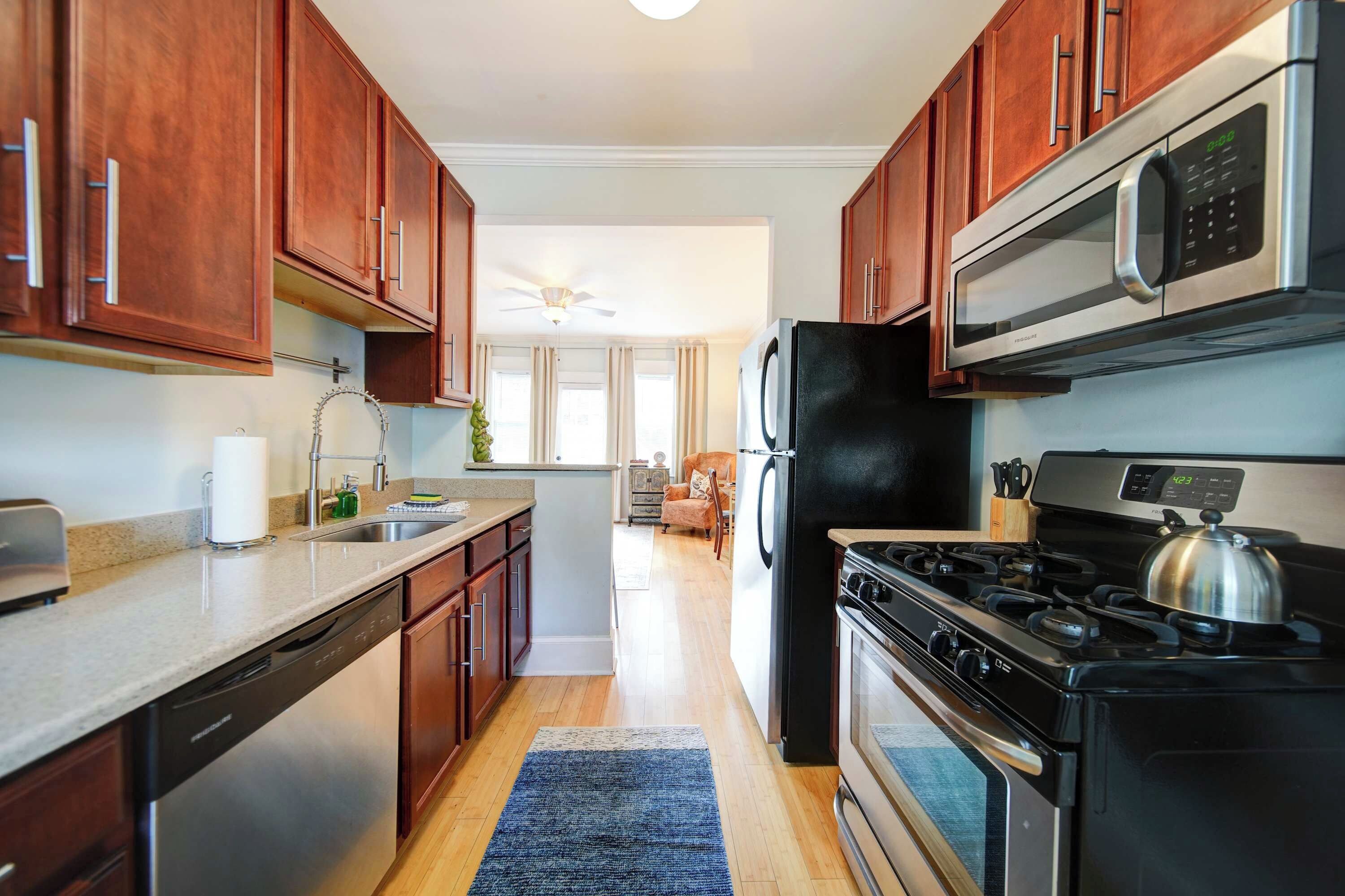 A modern kitchen with wooden cabinets, stainless steel appliances, and a central island.