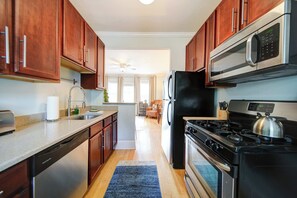 Een moderne keuken met houten kasten, roestvrijstalen apparatuur en een centraal eiland.