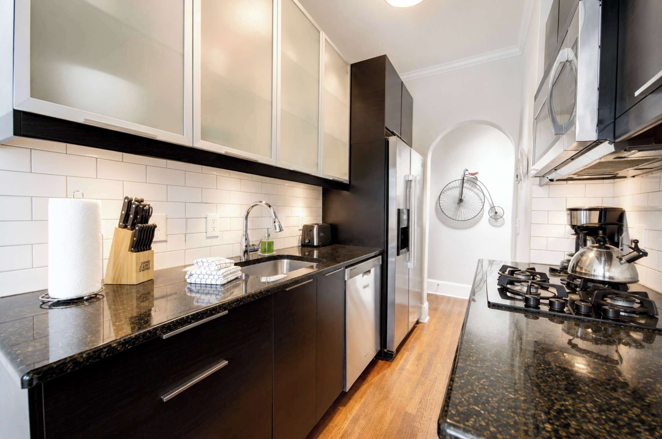 A modern kitchen with a stainless steel refrigerator, a gas stove, and a dishwasher.