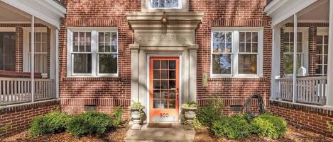 A brick building with a red door labeled "Queens Terrace" and the number 500.