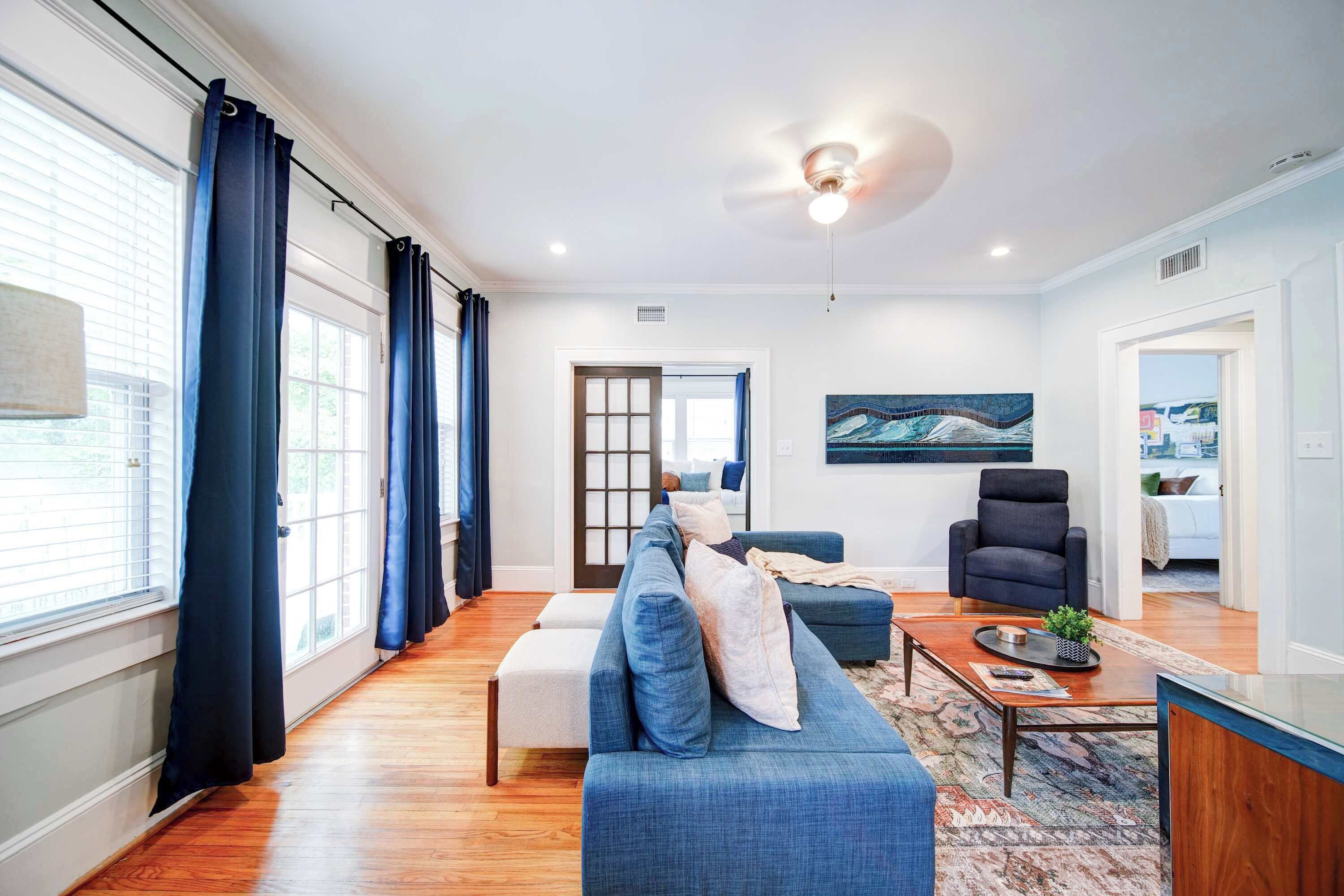 Una sala moderna con sofá, sillón y mesa de centro.