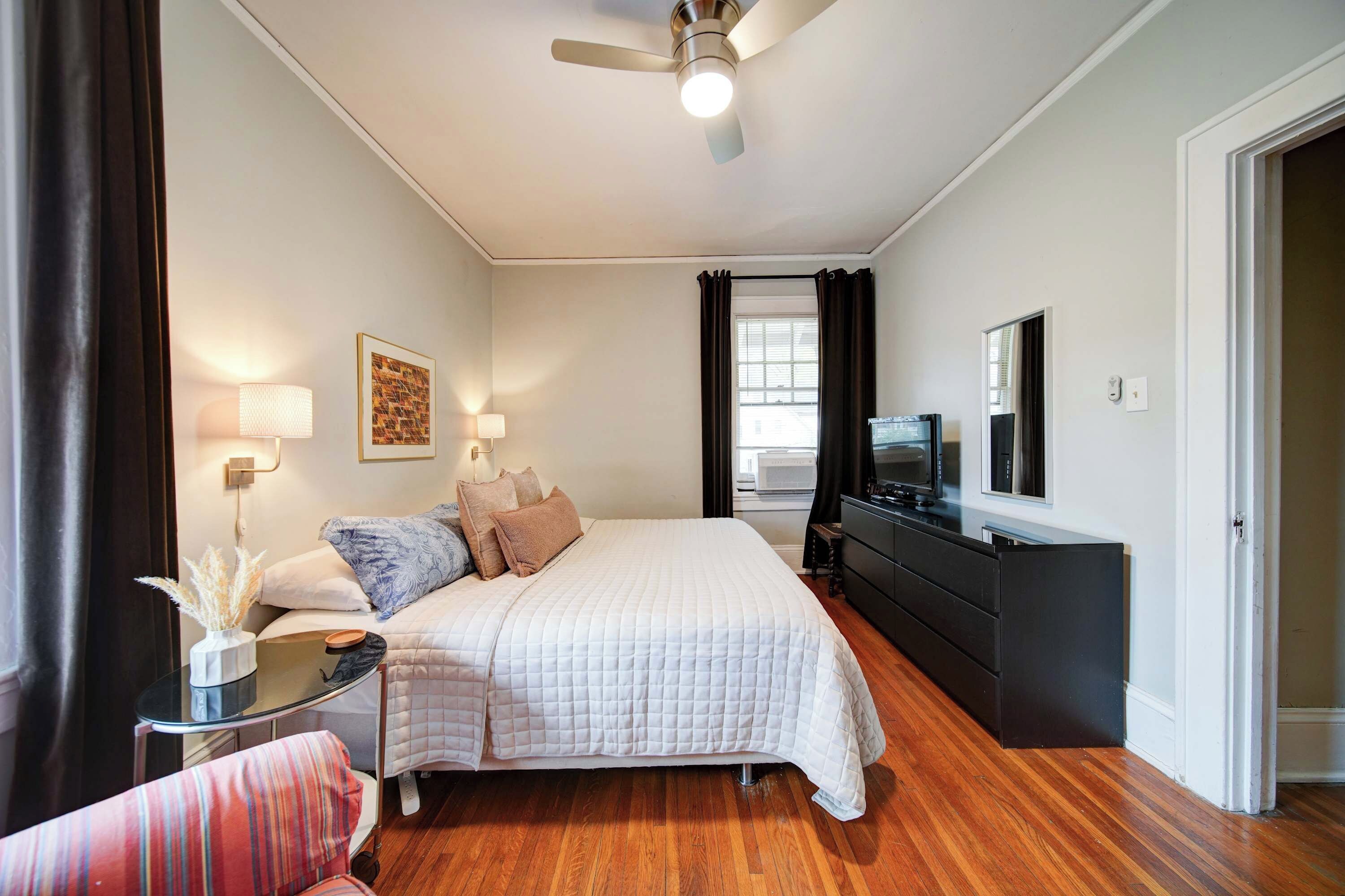 Comfortable Charlotte retreat with a king bed, hardwood floors, natural light, and bedside lighting.