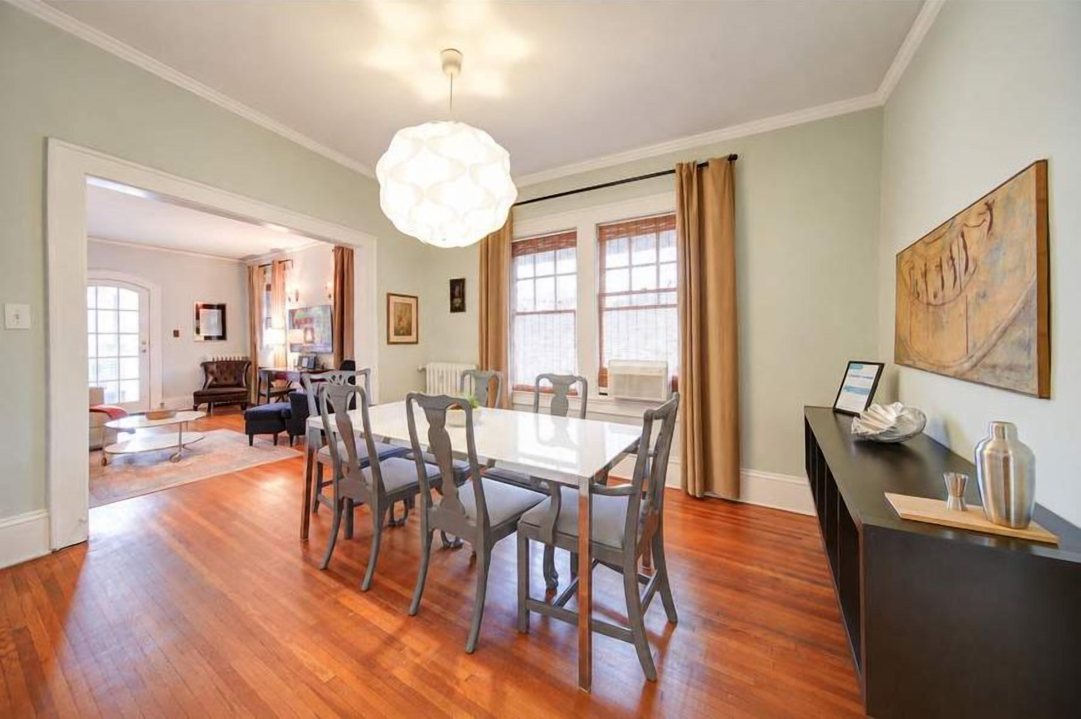Bright, spacious dining area with hardwood floors and an open flow into the living room.