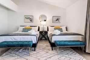 A hotel room with two beds, a round mirror, and a small table between them. - Stunning 5BD Escape w/ Billiard Room & Pool! (North Las Vegas)